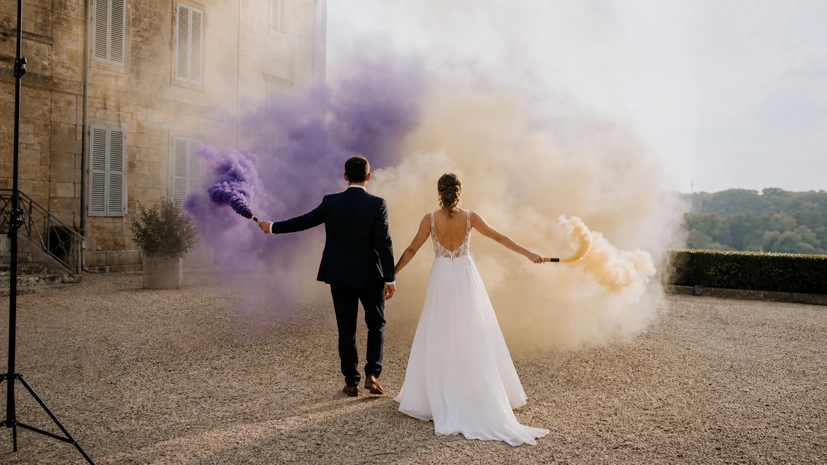 Couple photographié de dos avec fumigènes colorés orientés loin de lui.