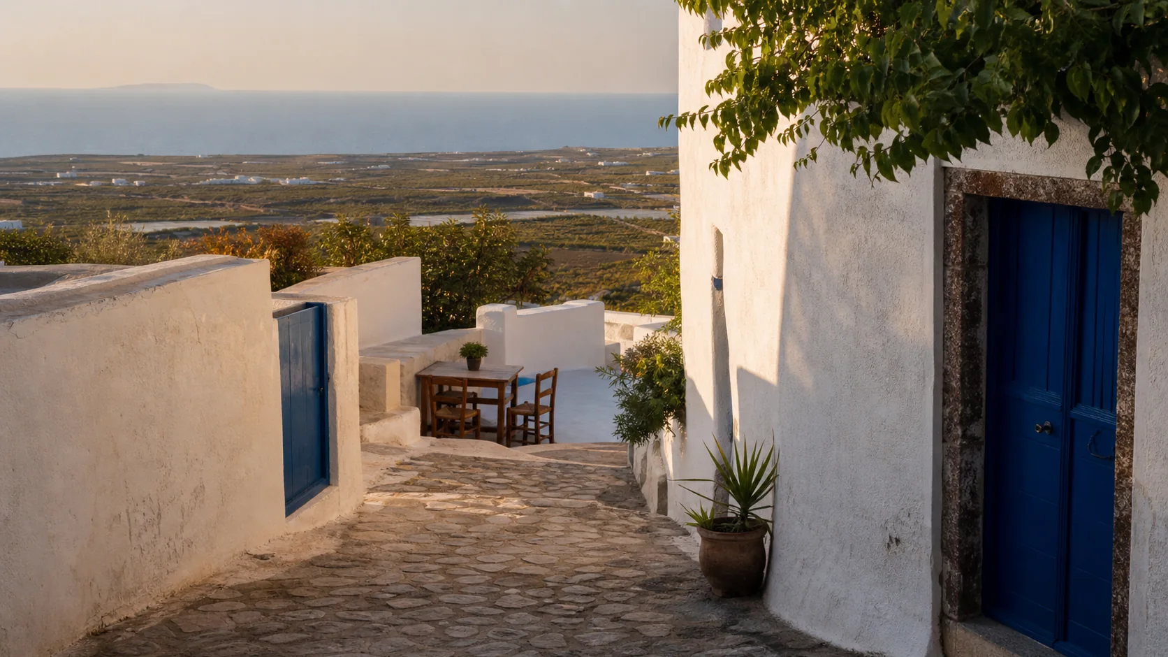 Ruelle calme aux murs blancs et portes bleues, inspiration pour le village de Pyrgos à Santorin