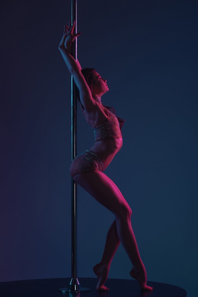 Sensual woman exercising pole dance